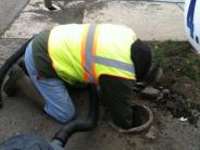 utility worker cleaning pipe